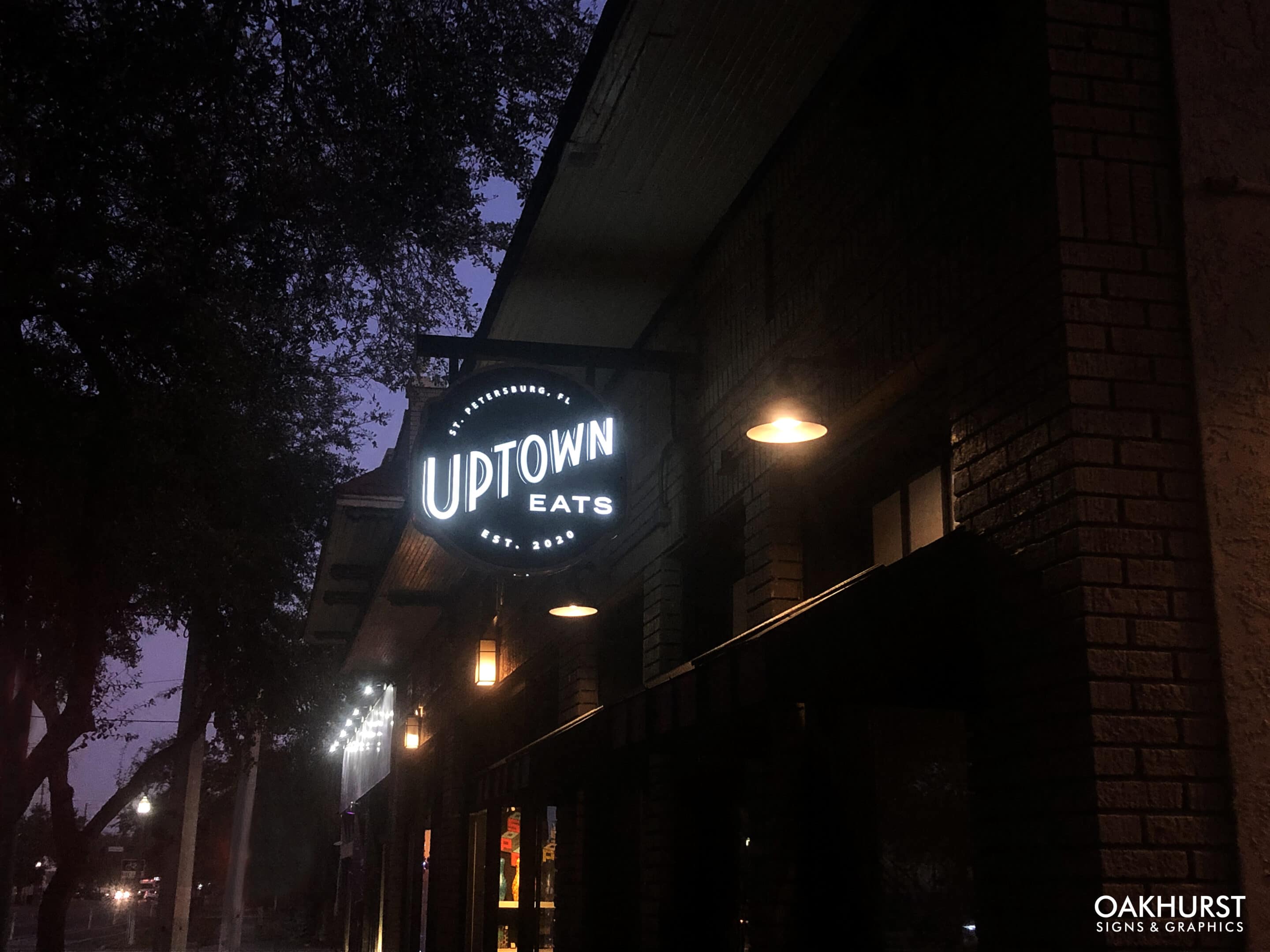 Uptown Eats signage illuminated at night